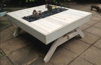 Garden table made from pallets, with a planter in the tabletop center.