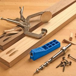 Pocket hole jig and clamps with drill bit.