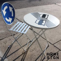 Folding table and chair made partly with reclaimed street signal boards.