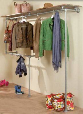 Wardrobe vestibule with coat hangers on steel rails from scaffolding.